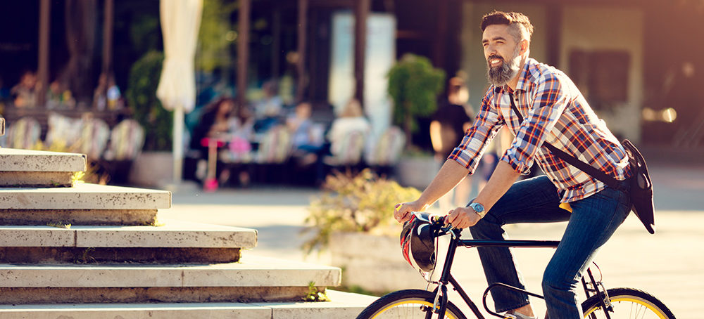 Young man cycling in smart city